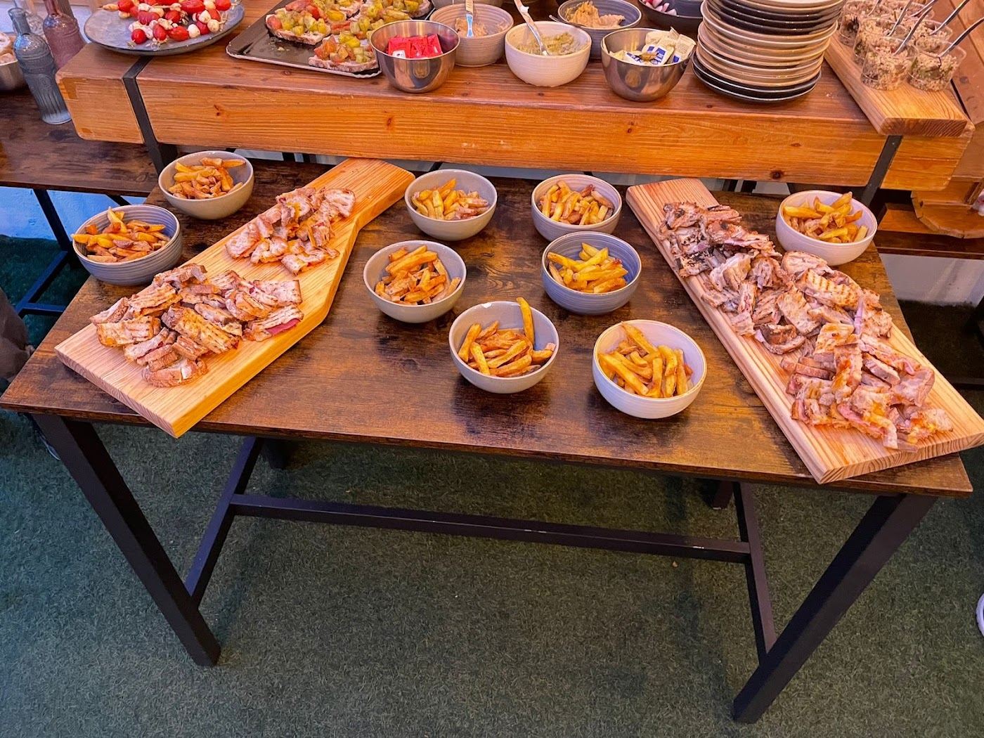 Planches en bois avec bouchées et ramequins de frites, buffet de réception.
