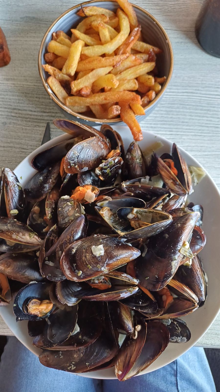 Moules marinières et bol de frites maison.