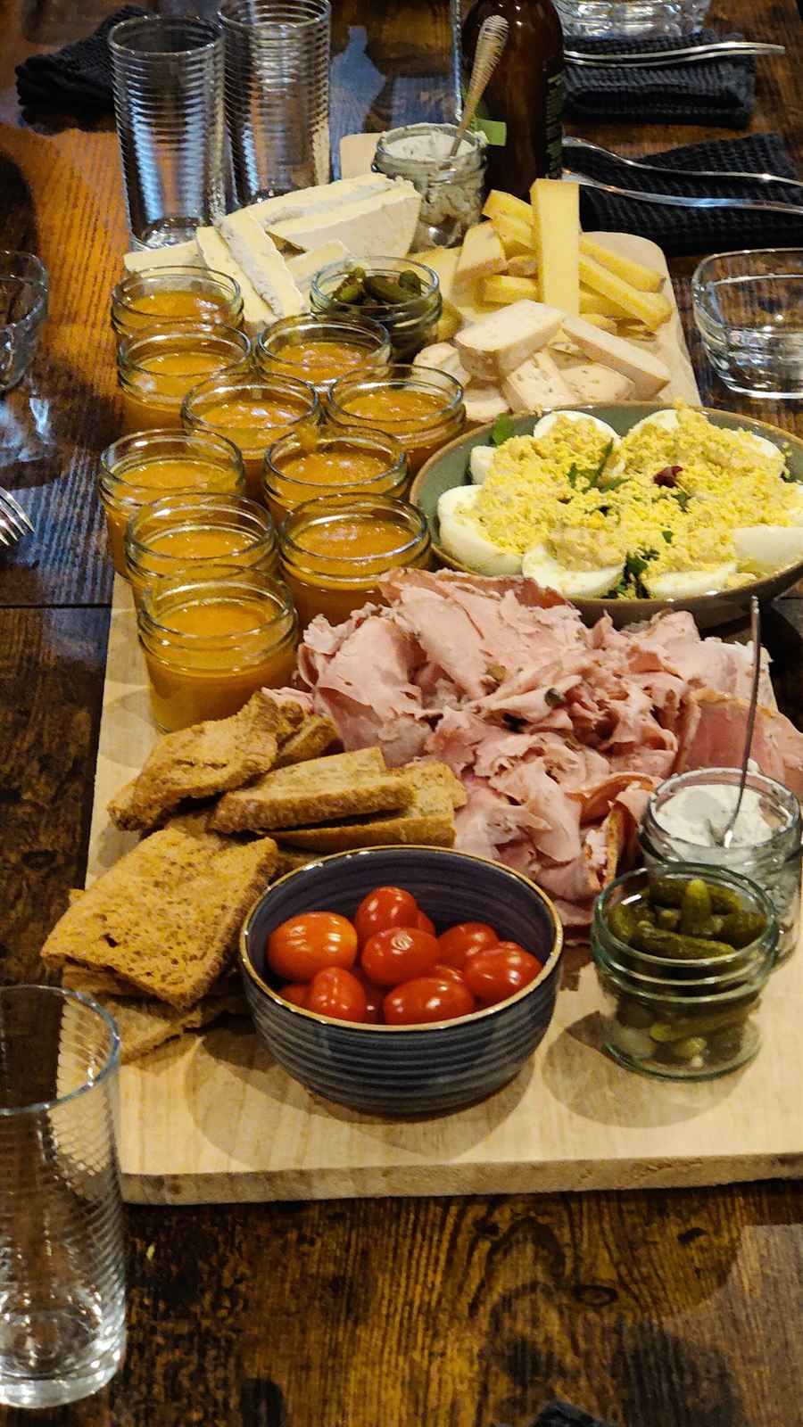 Planche à partager : jambon, fromages, œufs mimosa, tomates cerises, olives et verrines.